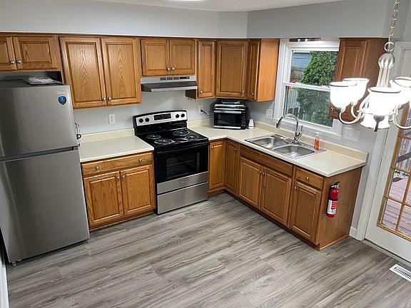 Kitchen with new appliances, lighting, and flooring.