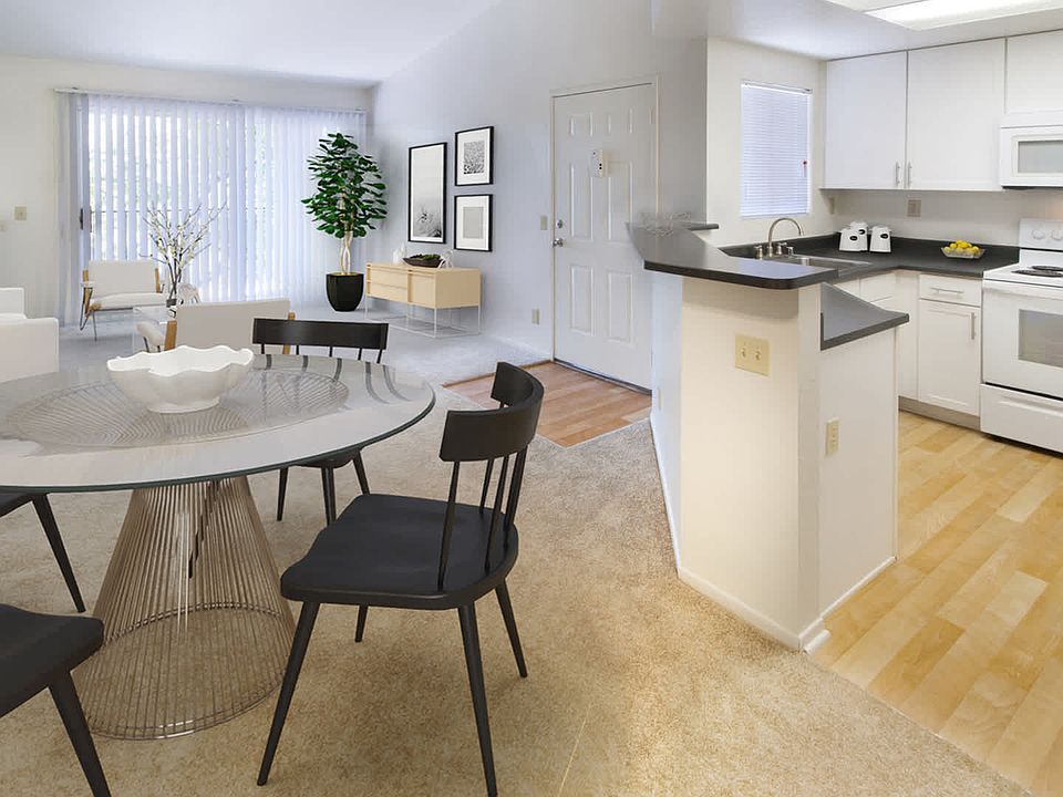 Kitchen and Carpeted Living Room with Balcony