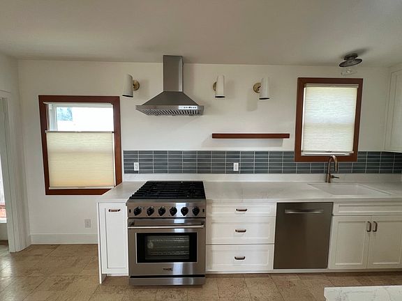 Kitchen includes gas stove, dishwasher, large farm sink with disposal, pull out pantry