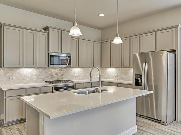 Gorgeous designer kitchen with stainless steel appliances and quartz counters.