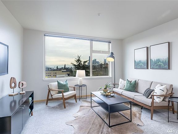 Spacious great room with its giant window providing wonderful light and overlooking downtown, the stadiums, Elliott Bay, and the Olympic mountains!