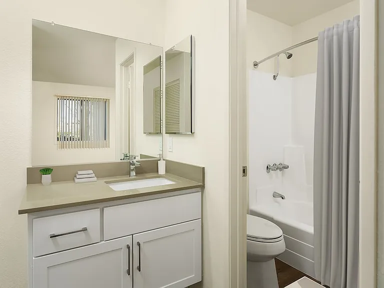Renovated I bath with grey quartz countertops, white cabinetry, and hard surface flooring