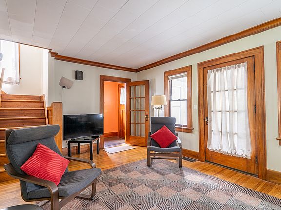 Living room showing entrance through front door and via glass door to LR. Door to front porch on right. Half bathroom is opposite front door.