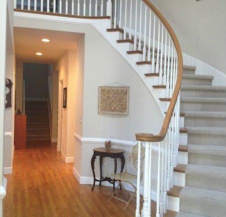 Formal dining room with built in cabinets, wrought iron chandelier, large window, chair rail & crown molding.