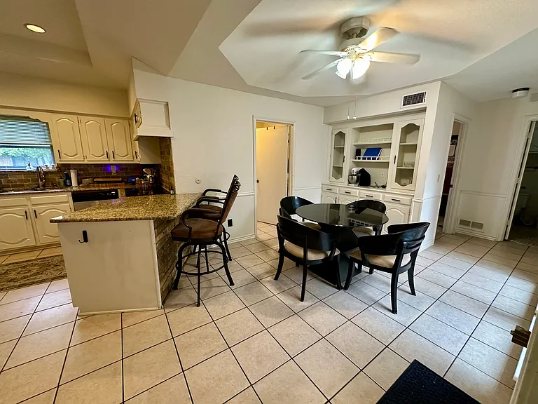 Dining area with baseboards, ceiling fan, and light tile patterned floors