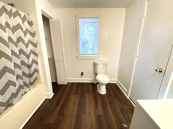 The same new and waterproof luxury vinyl plank floors have been installed throughout the apartment. Note the closet to the left. This full bath includes a bathtub/shower combo and a brand new toilet.