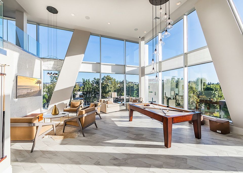 Clubhouse with floor-to-ceiling windows, pool table and pulsh seating.