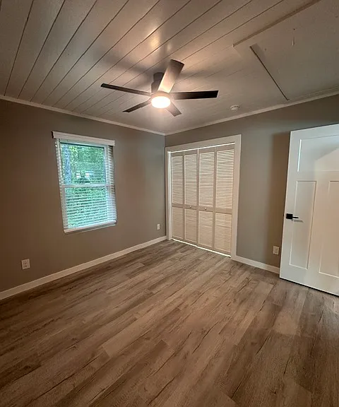 Bedroom #1 with upgraded custom shiplap ceilings, ceiling fan, and closet