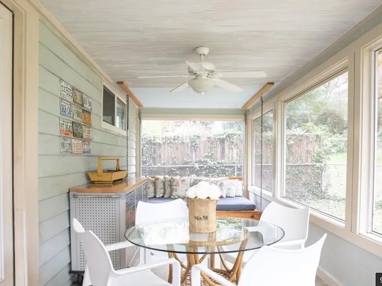 Back screened in porch with double size swinging day bed and glass topped table with seating for four.