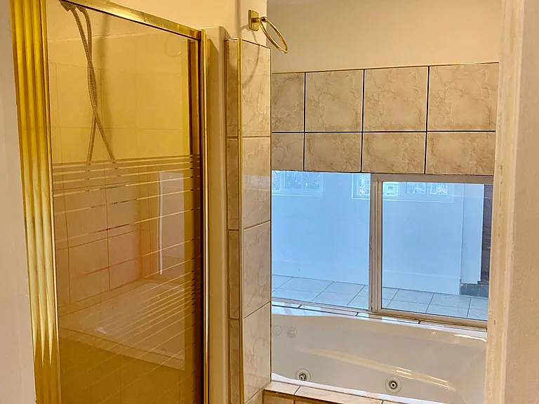 Shower stall and tub, tub looks out onto sleeping porch