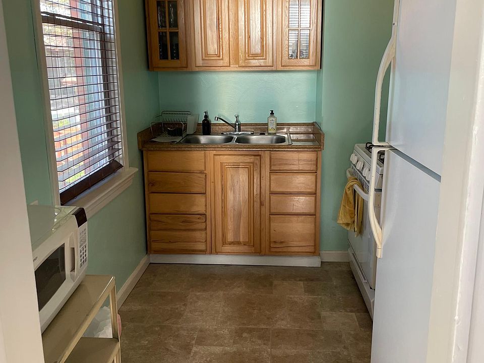 Kitchen stocked with utensils, dishware, cooking ware, microwave, toaster, spices and dish towels