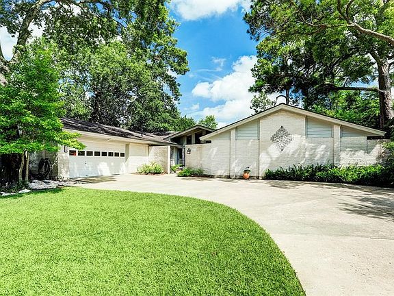 The oversized two-car garage has deep cabinetry which holds large plastic totes. It also boasts a large workshop to house all the tools and gadgets as well as a door to the side patio to access the storage shed.