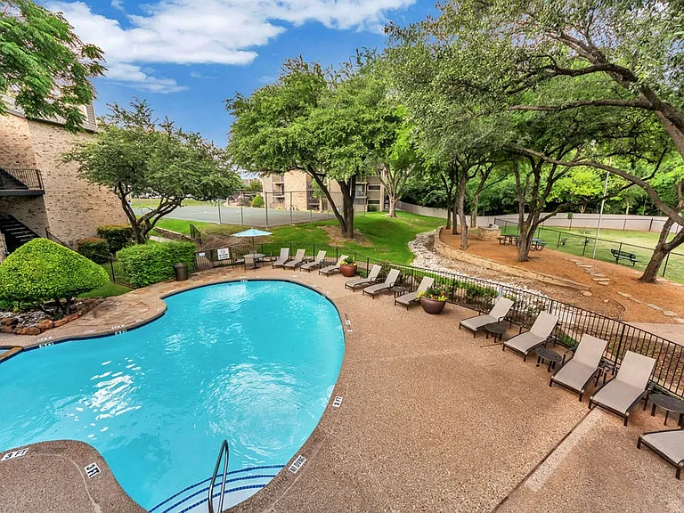 Resort-style swimming pool with sun deck and lounge seating at River Park Apartments in North Dallas