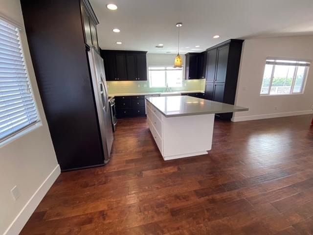 Island kitchen, stainless appliances, pantry, and dining area