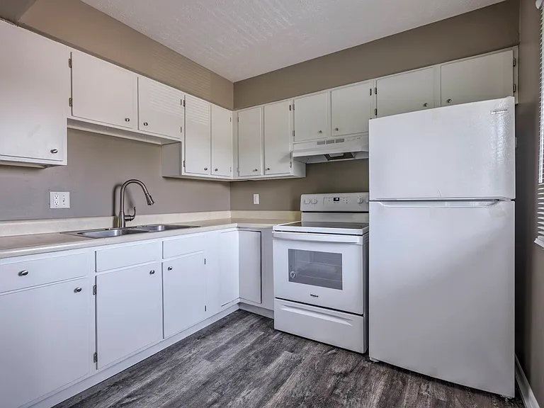 Grey walls and white cabinets in a kitchen at Ashland Park Apartments.