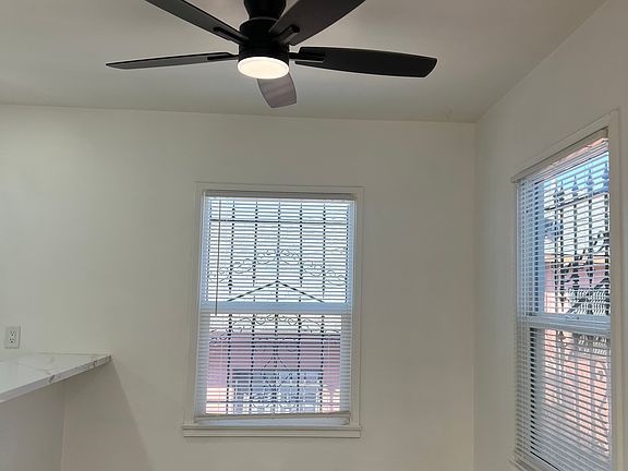 Dining area with large windows that invite a refreshing breeze, complemented by a remote-controlled ceiling fan with integrated lighting.