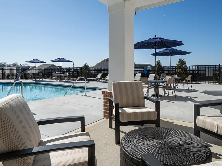 Covered patio on the pool deck with lounge seating.