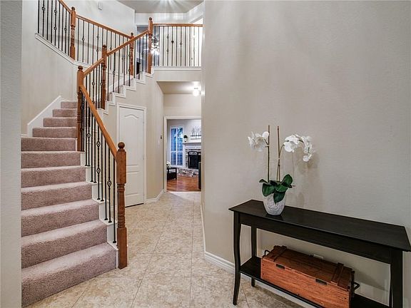 Come on in to the inviting two-story entry with curved iron baluster staircase.