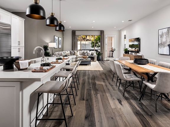 This image showcases the kitchen and dining space within the Villas Plan 1 model home.