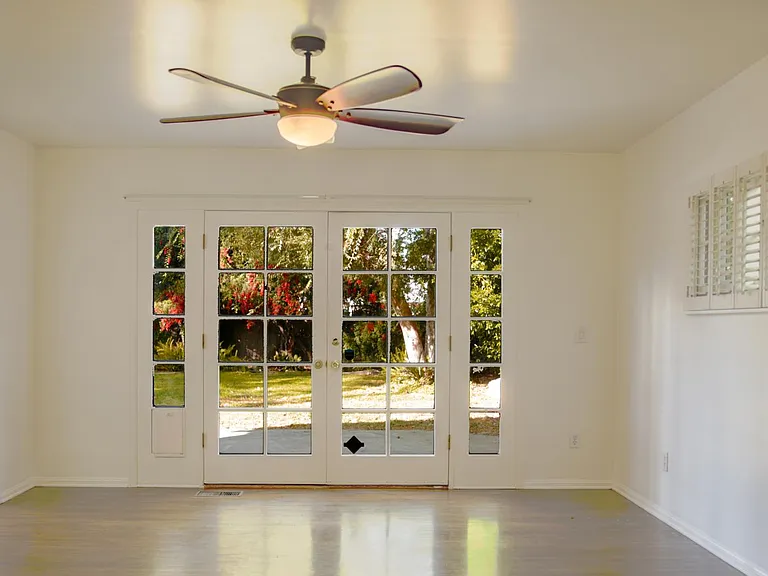 Master bedroom French doors open to patio and colorful backyard patio. This is Northern exposure.