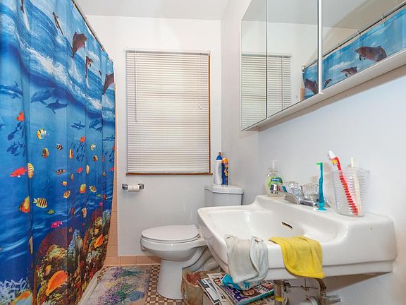 Main floor full bath with new toilet medicine cabinet and original tile that is in great shape.