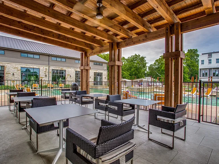 Tables in covered area adjacent to the pool