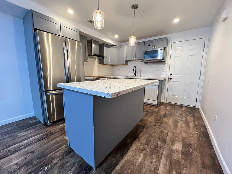 full sized fridge, microwave, center island, and lots of kitchen cabinet space.