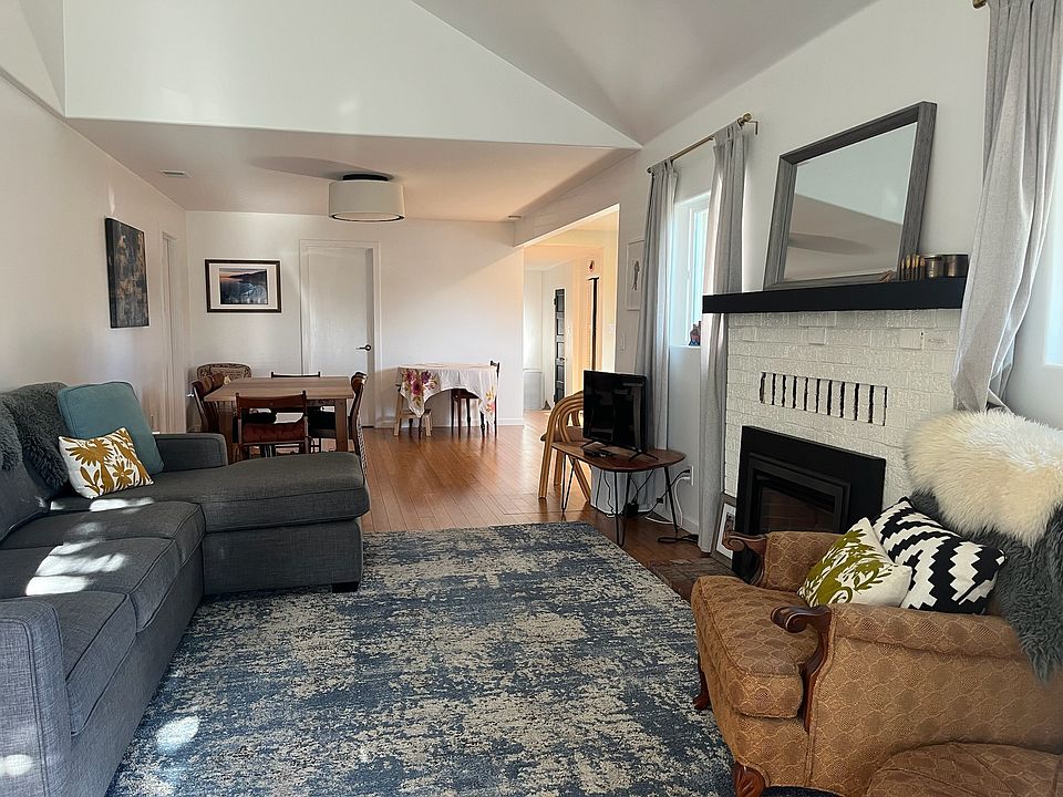 Open concept living and dinning room with fire place insert and lots of natural light