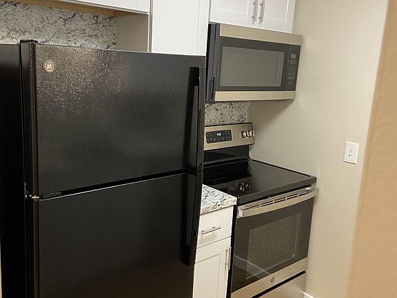 All newer appliances with glass top electric stove and matching over the range microwave.