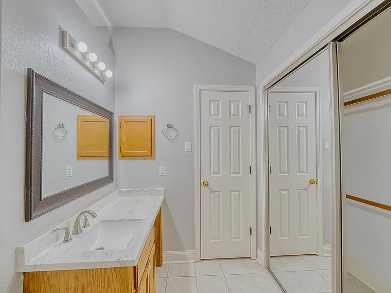 Spacious primary bath featuring a dual-sink vanity and dual mirrored closets.