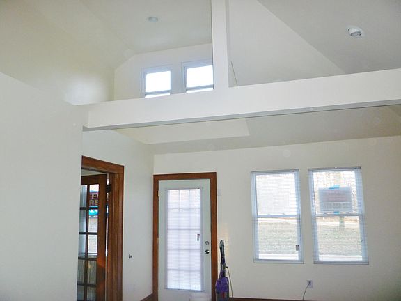 doorway to living room. vaulted ceiling , spacious and plenty of natural lighting. doorway to the left is a bedroom.
