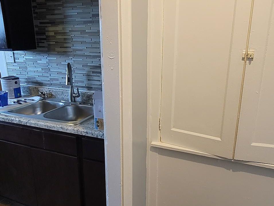 cubbard for additional storage in kitchen, nice granite and backsplash for sink.