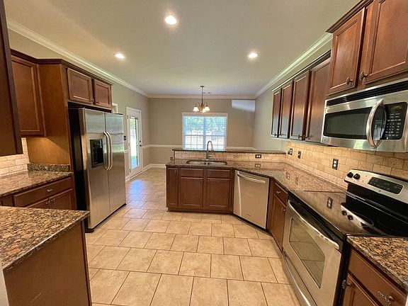 Kitchen with stainless steel appliances and under-cabinet LED lighting.