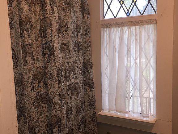 Vintage style bathroom has stained glass window.