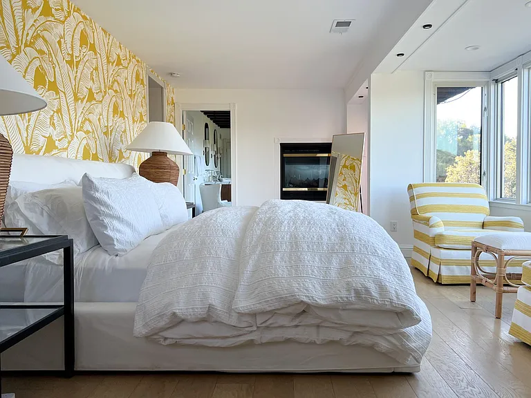 Primary Bedroom furnished with King Size bed, cozy club chairs in the bay window, and a large chest of drawers.
The Primary also has a private entrance.