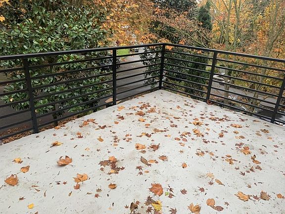 New railing just installed around the refinished patio. Looks out over the trees.