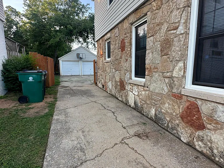 Pull through driveway leading to two car, garage in backyard