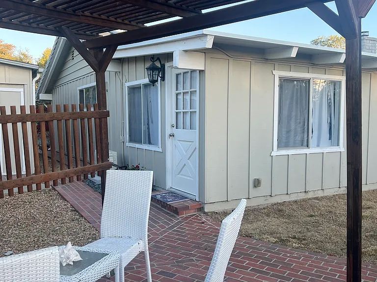 private covered patio and angle shot of guest house. Hobby/workshop on opposite side of pathway