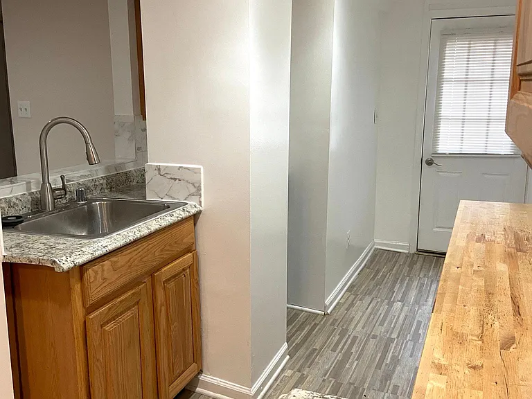 View of the kitchen sink with exit to the back door to the back yard. Has a street light at backyard.