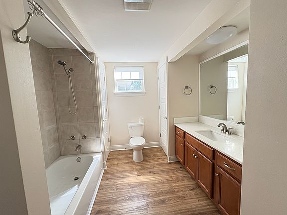 Spacious bathroom with new faucets, linen closet and large vanity with quartz counter.
