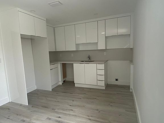 Full view of kitchen with white cabinetry.