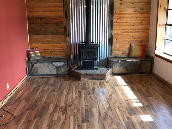 Living room- Hardwood floors, wood burning stove, slate bench and custom wall accent