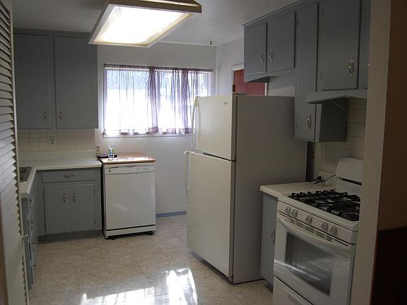 kitchen (grey cabinets), white appliances.