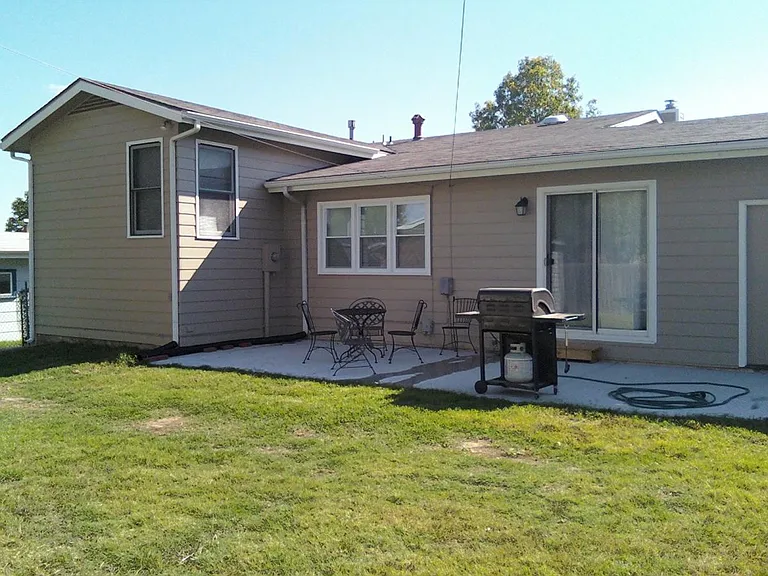 Back of house with new patio and privacy fenced yard