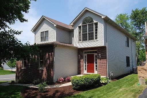 Front door view of house, partial brick, red front door