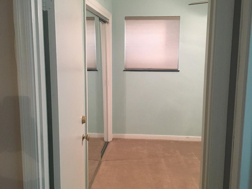 Bedroom 1 with ceiling fan, large closet with mirrored doors