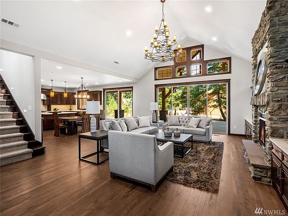As you open the ThermaTru custom double front door, warm northwest accents of rich floors, custom cabinetry, a solid stone floor to ceiling fireplace with views of your lush green private yard await. 