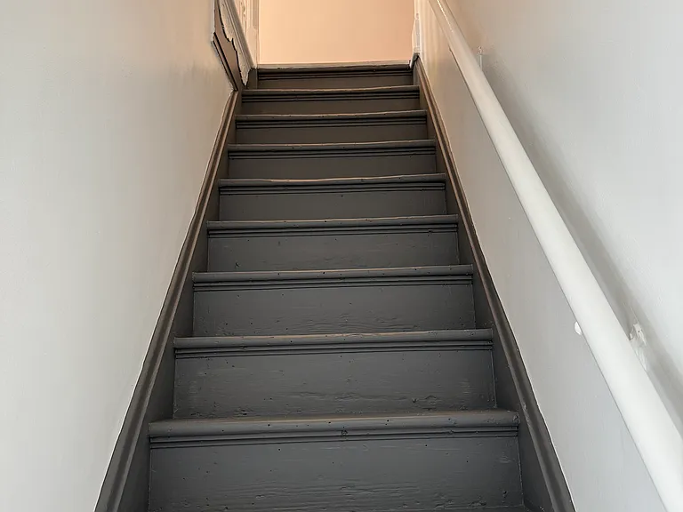 Steps leading down to the 1st floor with good, hallway lighting above
