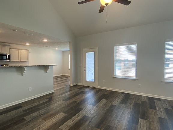 Great room with high ceiling and natural lighting, ceiling fan with light, laminate flooring on 1st