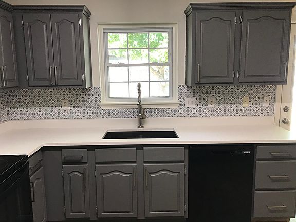 Kitchen with new countertops, sink, and disposal
